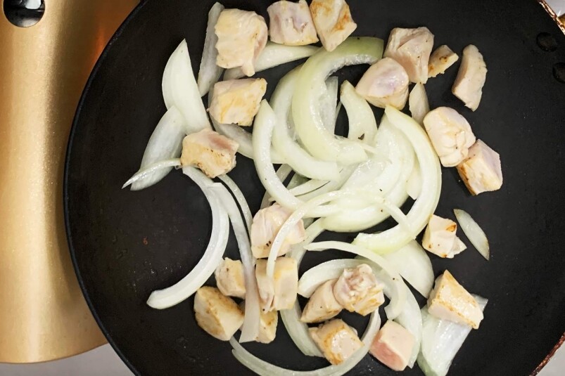 洋蔥切絲，雞肉切粒備用。燒熱鑊，加入油，快炒雞胸和洋蔥。