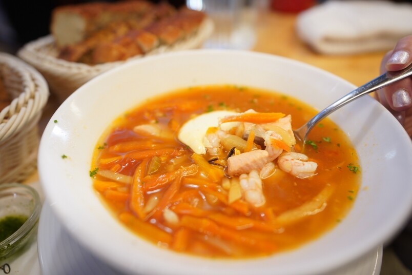 橙紅色的海鮮湯用上多款海鮮和鮮魚熬煮湯底，配料全是滿滿的鮮蝦、魚
