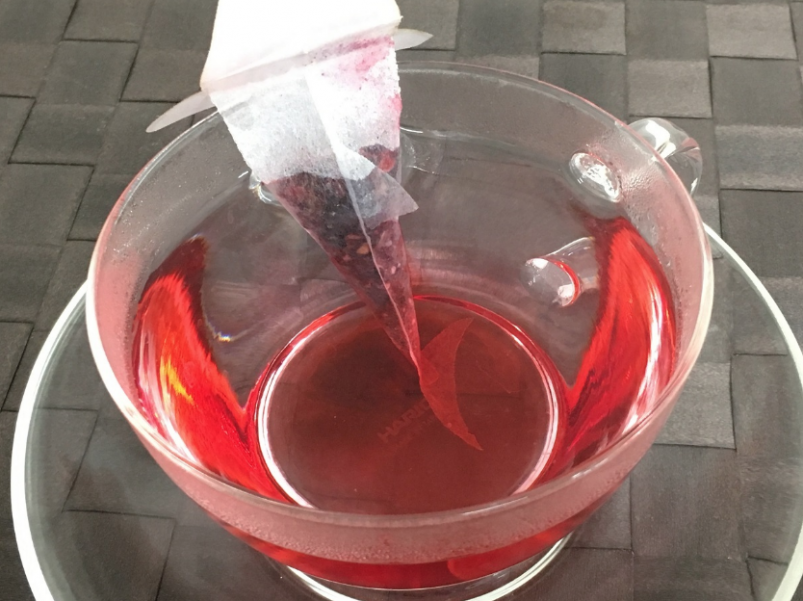 將茶袋放入盛在熱水的杯子中，茶包裹面的玫瑰木槿茶葉就會慢慢染紅