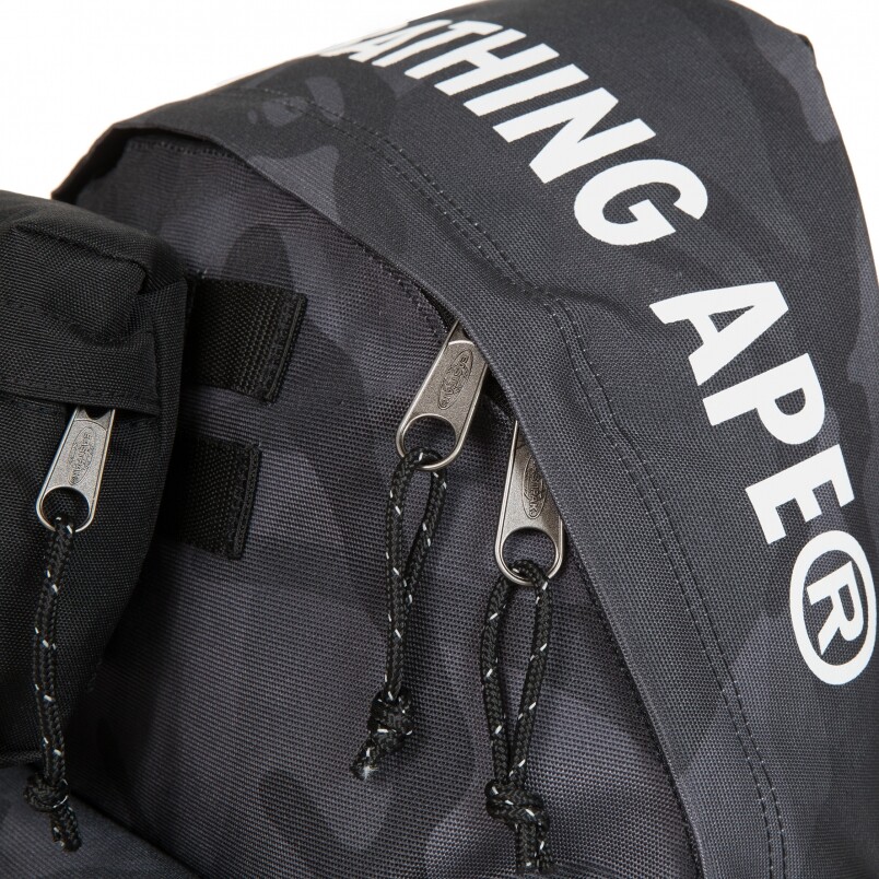 背包頂部、肩帶及手抽位置印上AAPE by *A Bathing Ape® 標語，其簡約全黑配色內襯與